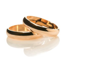 Altın alyanslar. Beyaz arka planda yakın plan iki nişan yüzüğü, yeni evliler için yansımalı makro mücevher..