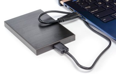 USb 3.0 kablosu ile laptopa bağlı harici disk diski. Taşınabilir kaputtaki veri depolama kavramı. Beyaz yüzeyde gölgeli yakın çekim..