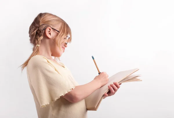 Colegiala escribiendo su tarea — Foto de Stock