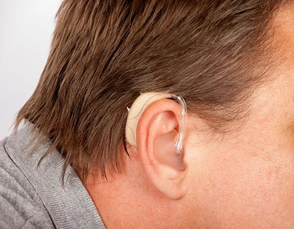 Ember fülükhöz, amelyben a hallókészülék — Stock Fotó