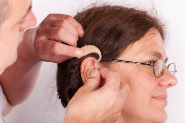Doktor bir işitme cihazı ekleme