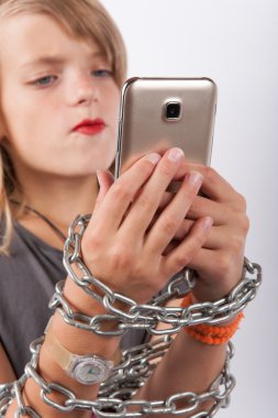 Genç kız Smartphone kullanarak bir zincirle zincirle 