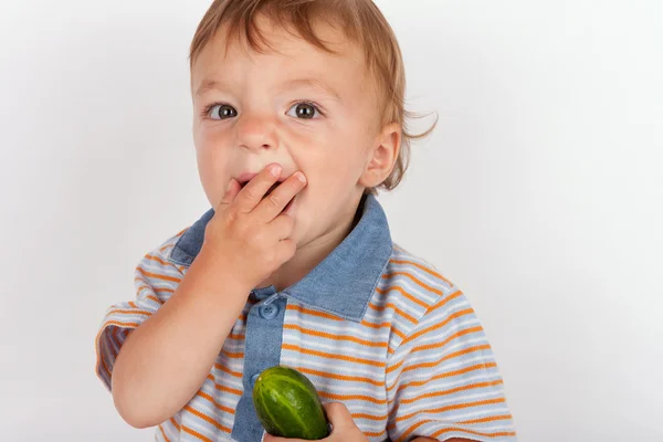 Голодний хлопчик їсть огірок — стокове фото