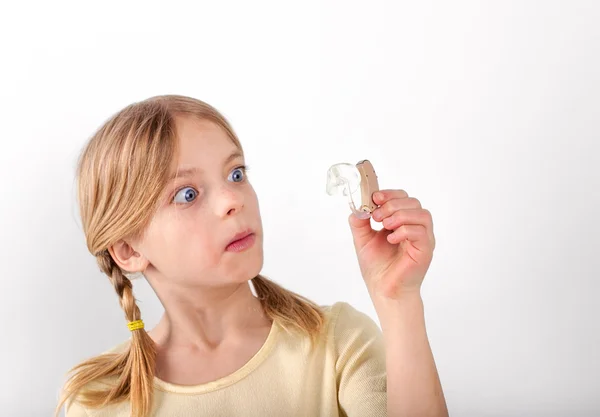 Girl looking at hearing aid — Stock Photo, Image