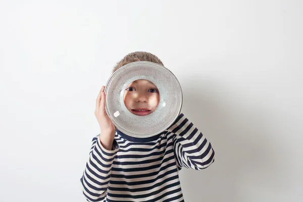 Jongen op zoek via studio lamp — Stockfoto