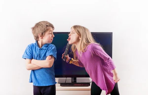 Siblings quarreling over remote control — Stock Photo, Image