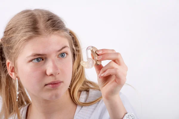 Девушка осматривает слуховой аппарат — стоковое фото
