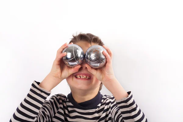 Niño travieso sosteniendo bolas de petanca — Foto de Stock