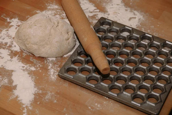 Frau formt selbst gemachte Knödel mit Ohren in der Küche. Knödel in Nahaufnahme modellieren. Weibliche Hände formen Knödel. — Stockfoto