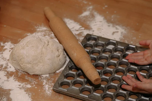 Frau formt selbst gemachte Knödel mit Ohren in der Küche. Knödel in Nahaufnahme modellieren. Weibliche Hände formen Knödel. — Stockfoto