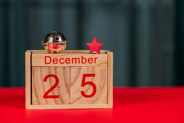 Photo of a wooden calendar on a red background, christmas, wooden toys, place for text