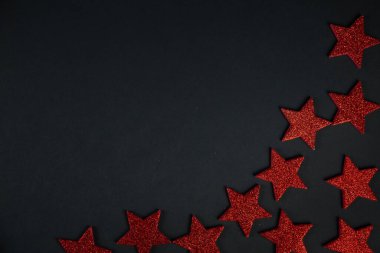Noel konsepti. Siyah arkaplanda kırmızı yıldızlar, noel dekoru, düz çizgi.