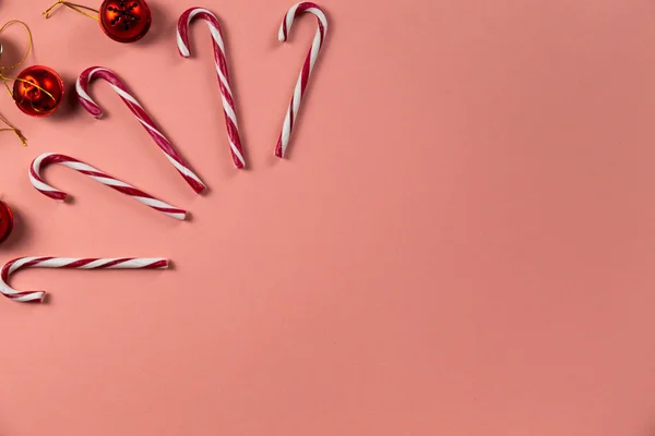 Pastel pembe arka planda bir sürü şeker kamışlı Noel çanları. Fotokopi alanı olan bayram kutlama kartı.