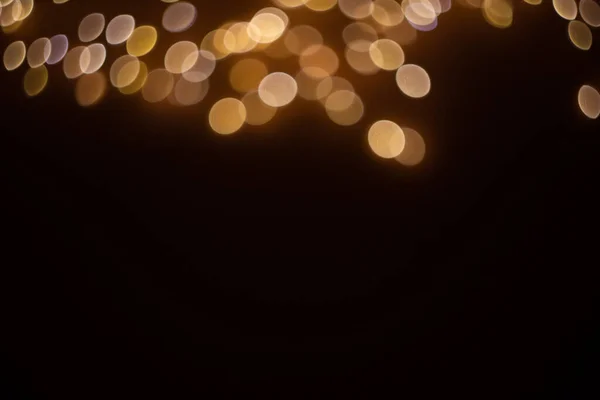 Siyah arkaplandaki altın soyut bokeh, parlak ışıklar