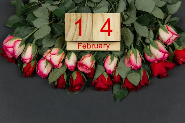 木製のカレンダーと暗い背景に休日のための赤いバラ バレンタインデーのテキストのための場所 — ストック写真