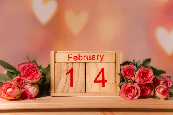 Ahşap bir arka planda pembe güller, yazı için beyaz bir yer, sehpa, 14 Şubat veya 8 Mart bayramı için pembe arka plan, Sevgililer Günü