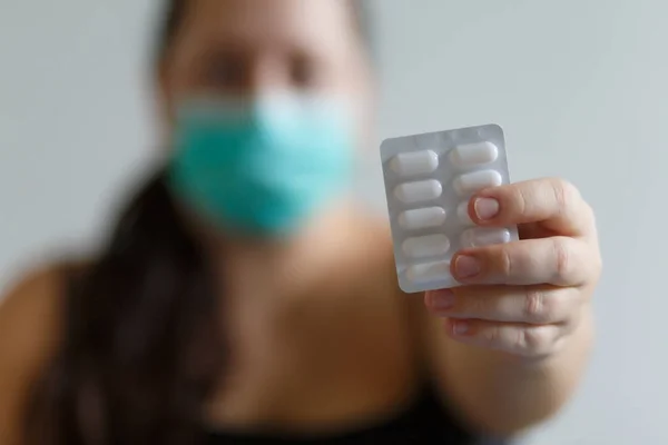 Beyaz arka planda maskeli bir kız elinde tabletler, tıbbi tema