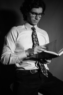 Genç adam gözlüklü bir kitap okuma.