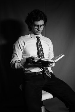 Genç adam gözlüklü bir kitap okuma.