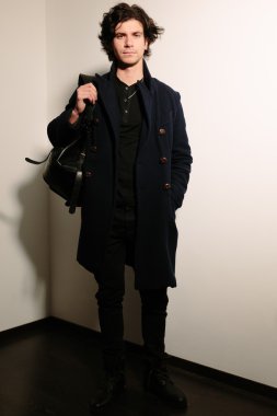 Yakışıklı genç bir siyah montlu bir çanta.