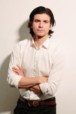 Genç adam kollarını katlanmış.