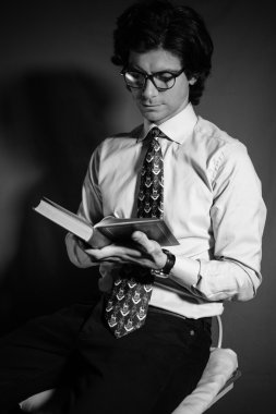 Genç adam gözlüklü bir kitap okuma.