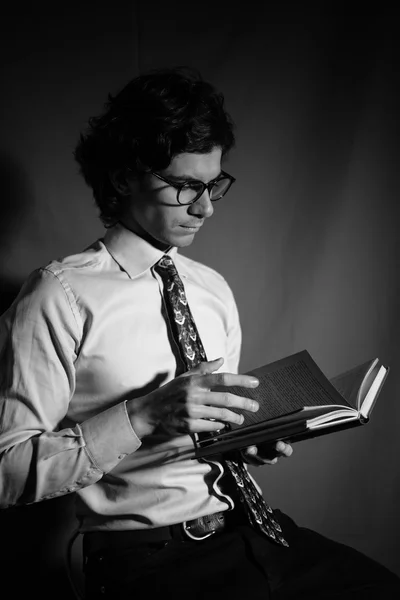 Молодой человек читает книгу в очках . — стоковое фото