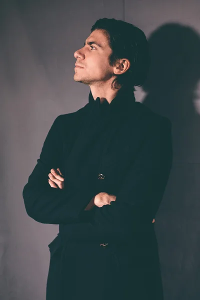 Modischer junger Mann im schwarzen Mantel. — Stockfoto