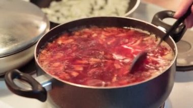 Çorba bir tencerede stired bir kaşık ile o zaman bir kapağı kapatın.