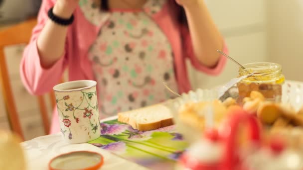 Jovem mulher tomando café da manhã e bebendo chá . — Vídeo de Stock