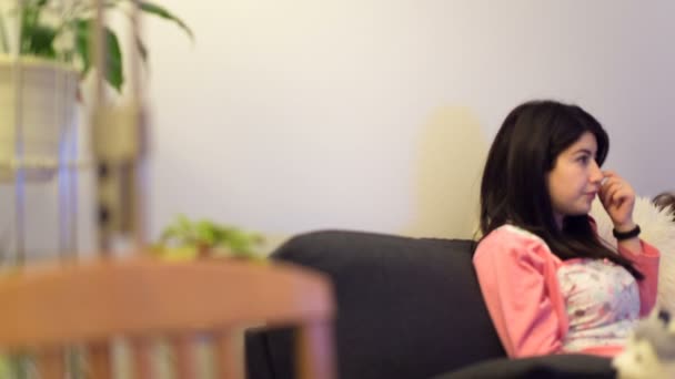 Camera moves from left to right and removes mother and the daughter on a sofa. — Stock Video