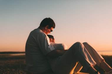 Kocası karısını bankta kucaklayan.