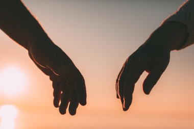 Çift el siluet bir gökyüzü ve deniz arka planda ulaşmak.