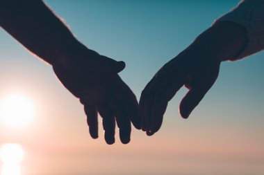 Çift el siluet bir gökyüzü ve deniz arka planda ulaşmak.