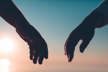 Çift el siluet bir gökyüzü ve deniz arka planda ulaşmak.