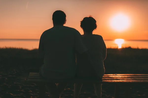 Доросла пара обіймається на заході сонця і моря . — стокове фото