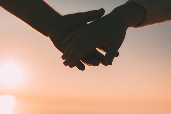 Paar Hände reichen Silhouette auf einem Himmel und Meer Hintergrund. — Stockfoto