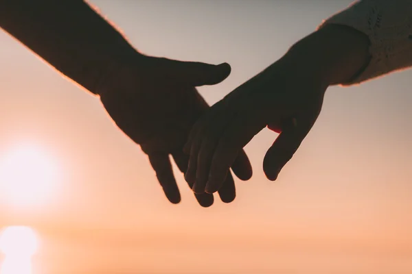 Paar Hände reichen Silhouette auf einem Himmel und Meer Hintergrund. — Stockfoto