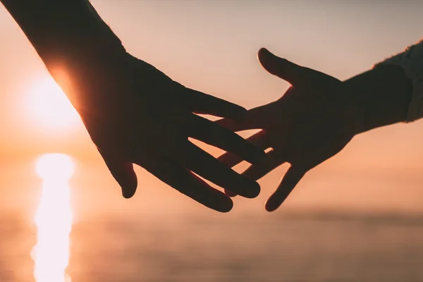 Couple hands reach silhouette on a sky and sea background. — Stock Photo, Image