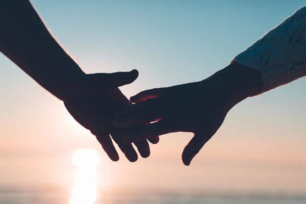 Couple hands reach silhouette on a sky and sea background. — Stock Photo, Image