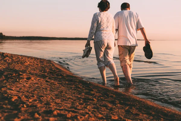 Erwachsenes Paar spaziert am Meeresufer. — Stockfoto