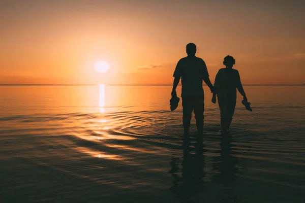 夕日と海のアダルト カップル立ってのシルエット. — ストック写真