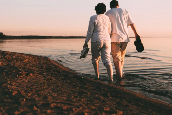 Доросла пара гуляє на березі моря . — стокове фото