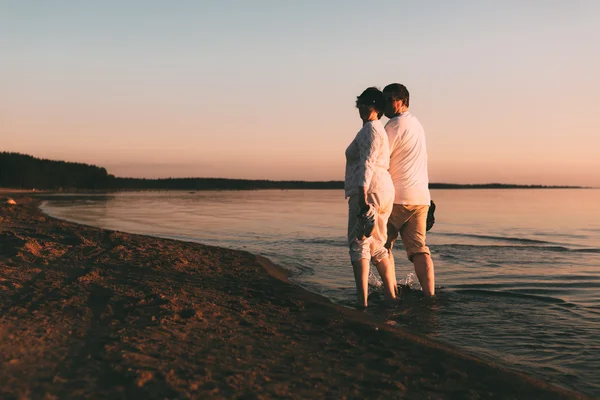 Pareja adulta camina en la orilla del mar . — Foto de Stock