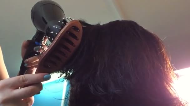 Friseur trocknet dem Kunden die Haare und stapelt sie mittels Haartrockner und Haarbürste. — Stockvideo