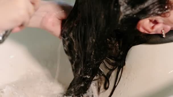 Kadeřník umýt hlavu klientovi s odbarvenými vlasy. — Stock video