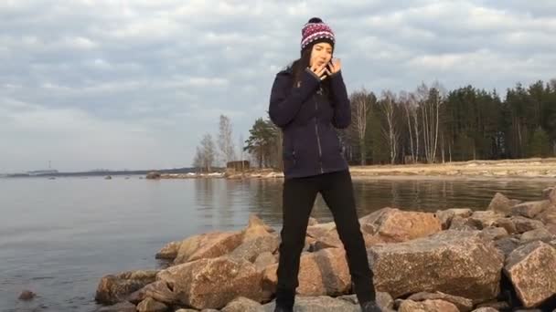 Dívka stojící krásně tancuje na kamenech nedaleko zálivu. — Stock video