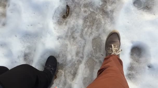 Dos personas caminando sobre la nieve del jardín . — Vídeo de stock