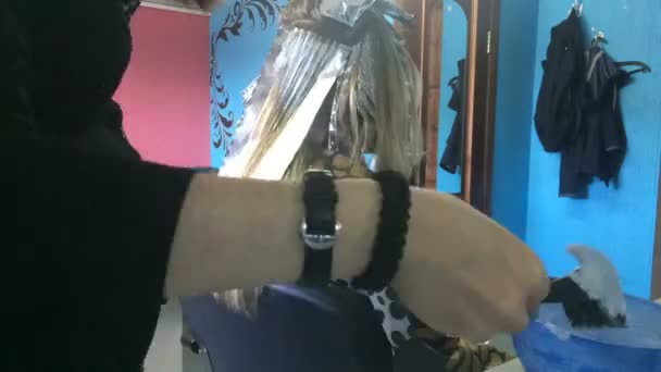 Coiffeur ne soulignant à la fille en utilisant des outils et une feuille . — Video