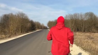 Sporcu kırmızı giysili kamera takip etsin park sokak üzerinde çalışır.